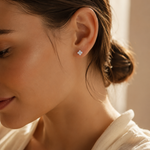 SigneNor Funkelnder Ohrstecker aus 925 Sterling Silber in Kleeblattform in warmer natürlicher Lichtstimmung getragen, mit weichem femininen Premium-Look.
