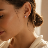 SigneNor Funkelnder Ohrstecker aus 925 Sterling Silber in Kleeblattform in warmer natürlicher Lichtstimmung getragen, mit weichem femininen Premium-Look.