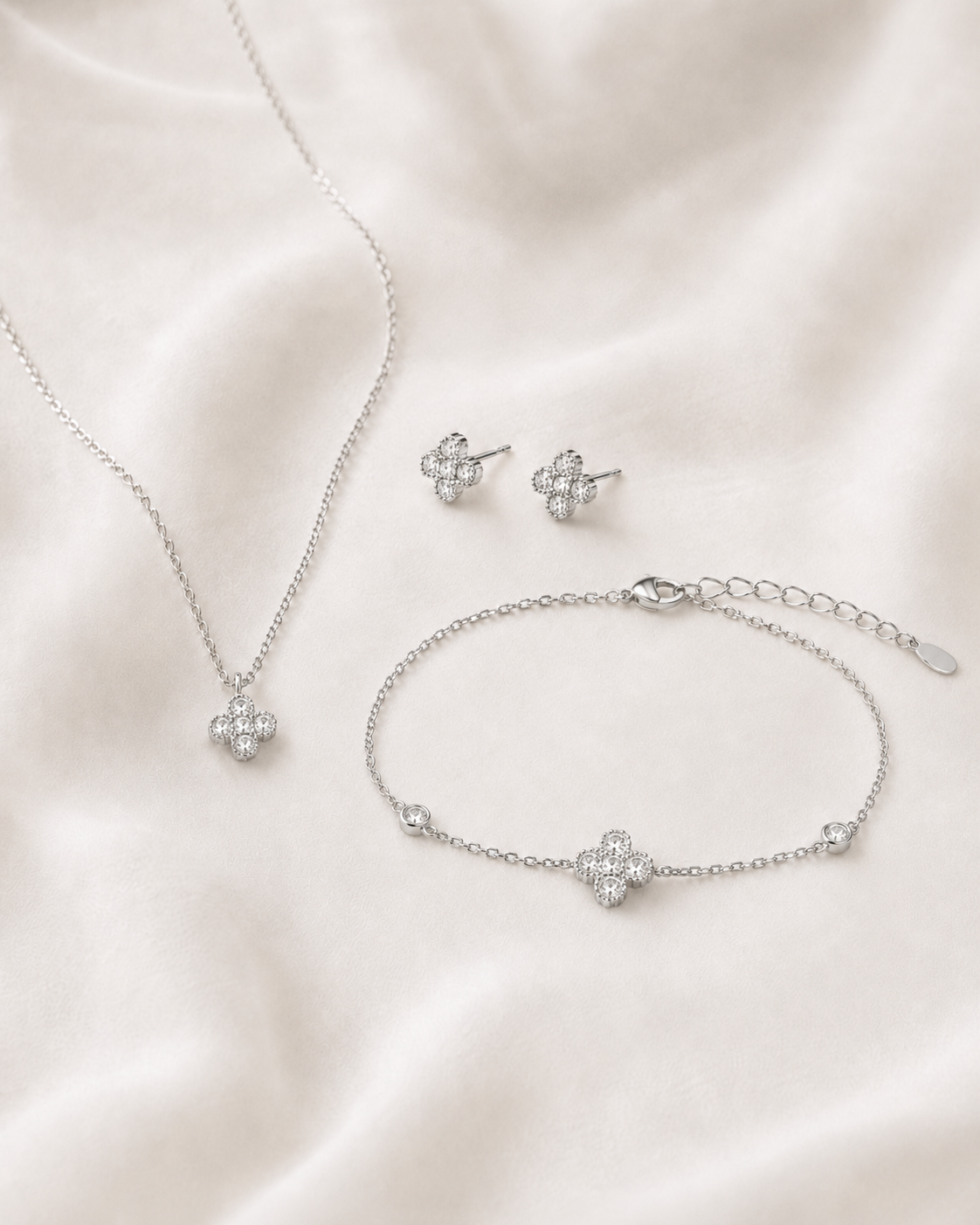 SigneNor Schmuckset aus 925 Sterling Silber von Novellara mit Halskette, Ohrsteckern und Armband im zarten Kleeblatt-Design auf hellem Satin.