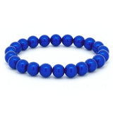 Elastisches Armband aus glänzenden, intensiv blauen Perlen in kreisförmiger Anordnung auf weißem Hintergrund.