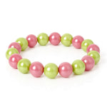 Ein Armband mit abwechselnd pinken und grünen glänzenden Perlen liegt auf einem weißen Hintergrund.