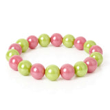 Ein Armband mit abwechselnd pinken und grünen glänzenden Perlen liegt auf einem weißen Hintergrund.