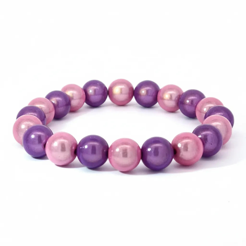 Ein elegantes Armband aus glänzenden rosa und violetten Perlen, gleichmäßig aufgereiht auf einem elastischen Band. Die Perlen schimmern im Tageslicht und zeigen einen sanften Farbverlauf zwischen zartem Rosa und kräftigem Violett.