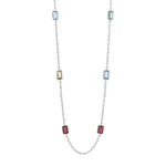 Silberne Halskette mit rechteckigen, facettierten Edelsteinen in verschiedenen Farben – Blau, Grün, Gelb und Rot – gleichmäßig entlang der feinen Gliederkette angeordnet.