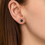 Nahaufnahme eines Ohrs mit einem eleganten Ohrstecker aus 925er Sterlingsilber, besetzt mit einem runden, facettierten Rauchquarz in warmem Braunton. Der Stein reflektiert das Licht dezent und verleiht dem Schmuckstück eine edle, natürliche Ausstrahlung.