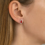 Nahaufnahme eines Ohrs mit einem eleganten Ohrstecker aus 925er Sterlingsilber und rotem Korallen-Cabochon in Marquiseform. Der Ohrstecker schimmert dezent und wirkt als stilvoller Farbakzent auf der Haut.
