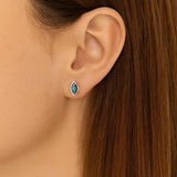 Nahaufnahme eines Ohres mit einem eleganten Ohrstecker in Marquiseform aus 925er Sterlingsilber, gefasst mit einem schimmernden Labradorit-Cabochon, der in Blau- und Grautönen irisierend leuchtet. Der Ohrstecker wirkt dezent und edel am Ohr getragen.