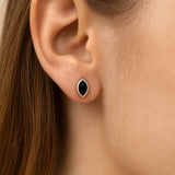 **Alt-Text:**
Nahaufnahme eines Ohrs mit einem eleganten Ohrstecker aus Sterlingsilber, besetzt mit einem tropfenförmigen, schwarzen Onyx-Cabochon in glatter Fassung. Der glänzende Stein verleiht dem Schmuckstück einen klassischen und zugleich modernen Look.
