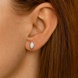 Nahaufnahme einer Frau in Seitenansicht mit einem kleinen, marquiseförmigen Ohrstecker aus Silber und schimmerndem Opal. Der etwa 5 mm lange Ohrring sitzt dezent am Ohrläppchen, während Haut und Haar in warmem, natürlichem Licht erscheinen.