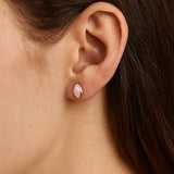 Nahaufnahme eines Ohrs mit einem eleganten Ohrstecker aus Sterlingsilber, gefasst mit einem zarten, rosafarbenen Rosenquarz-Cabochon in marquiseförmigem Schliff. Der sanfte Glanz des Steins verleiht dem Schmuckstück eine feminine und edle Ausstrahlung.