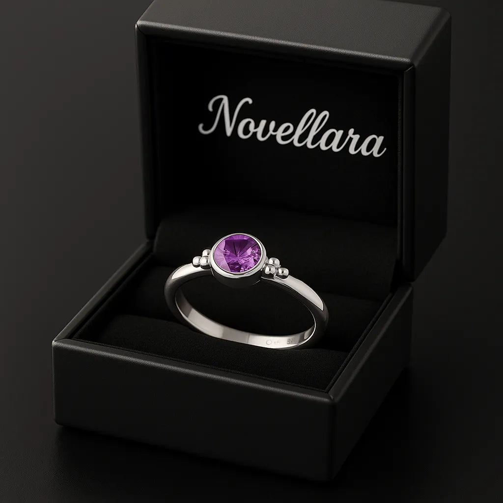 Silberring mit 4 mm violettem Amethyst in offener schwarzen Schmuckschachtel mit Novellara Logo im Deckel, edles Schmuck Geschenk und Produktdarstellung.