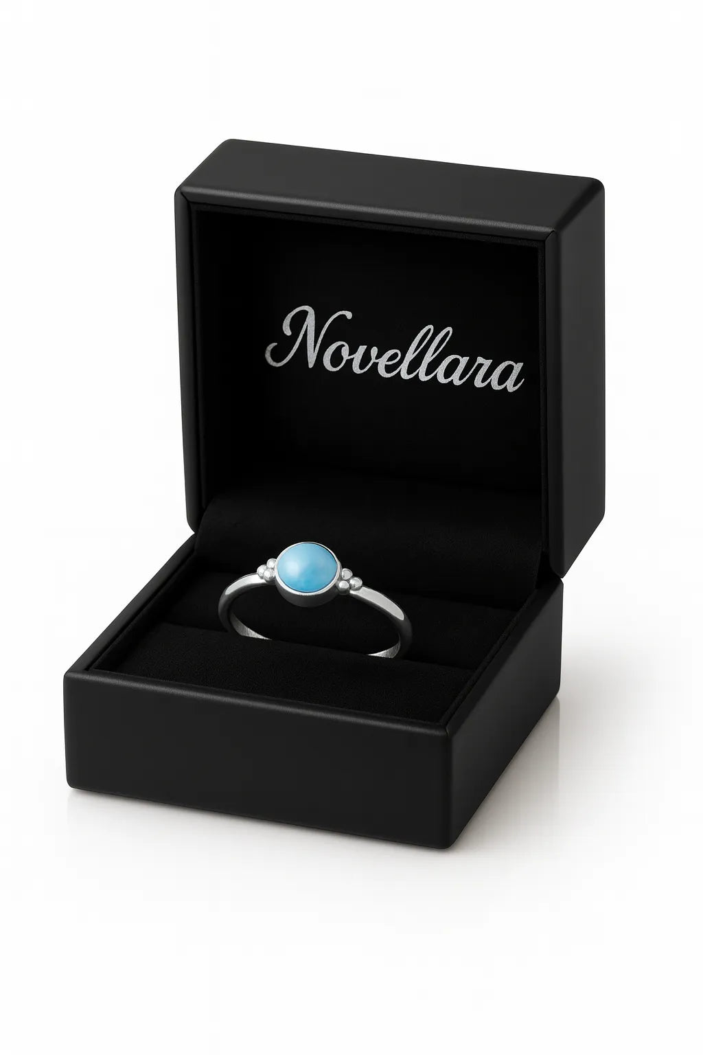 Eleganter Damenring aus Sterling Silber mit rundem blauem Chalcedon Cabochon (4 mm) in Zargenfassung, präsentiert in geöffneter schwarzer Schmuckbox mit Novellara Logo – hochwertiger Silberring mit hellblauem Edelstein als Geschenkidee für Frauen.