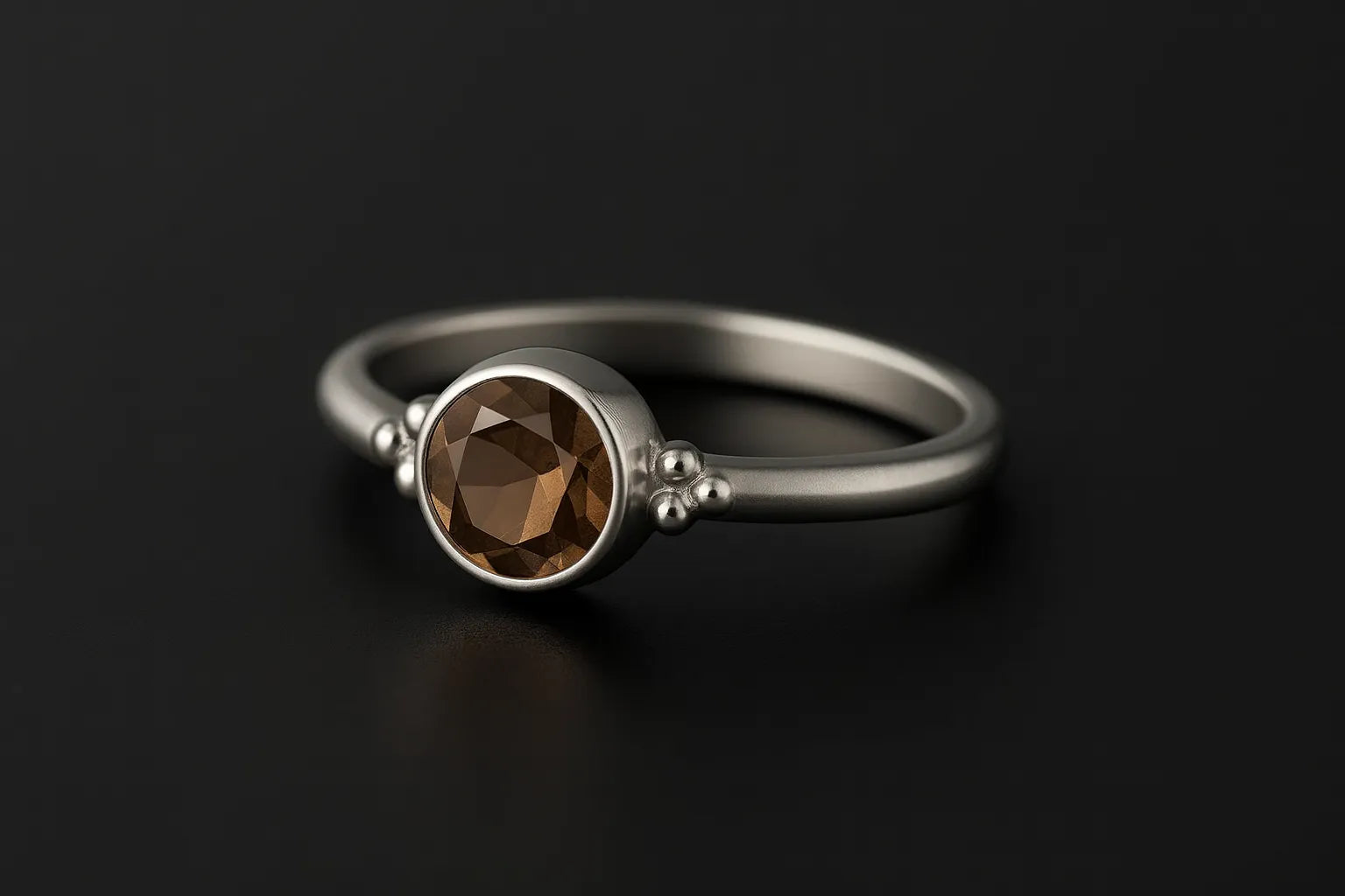 Damenring aus Sterling Silber mit rundem facettierten Rauchquarz in Zargenfassung – filigraner Silberring mit braunem Edelstein auf schwarzem spiegelnden Hintergrund, eleganter Schmuck für Frauen.
