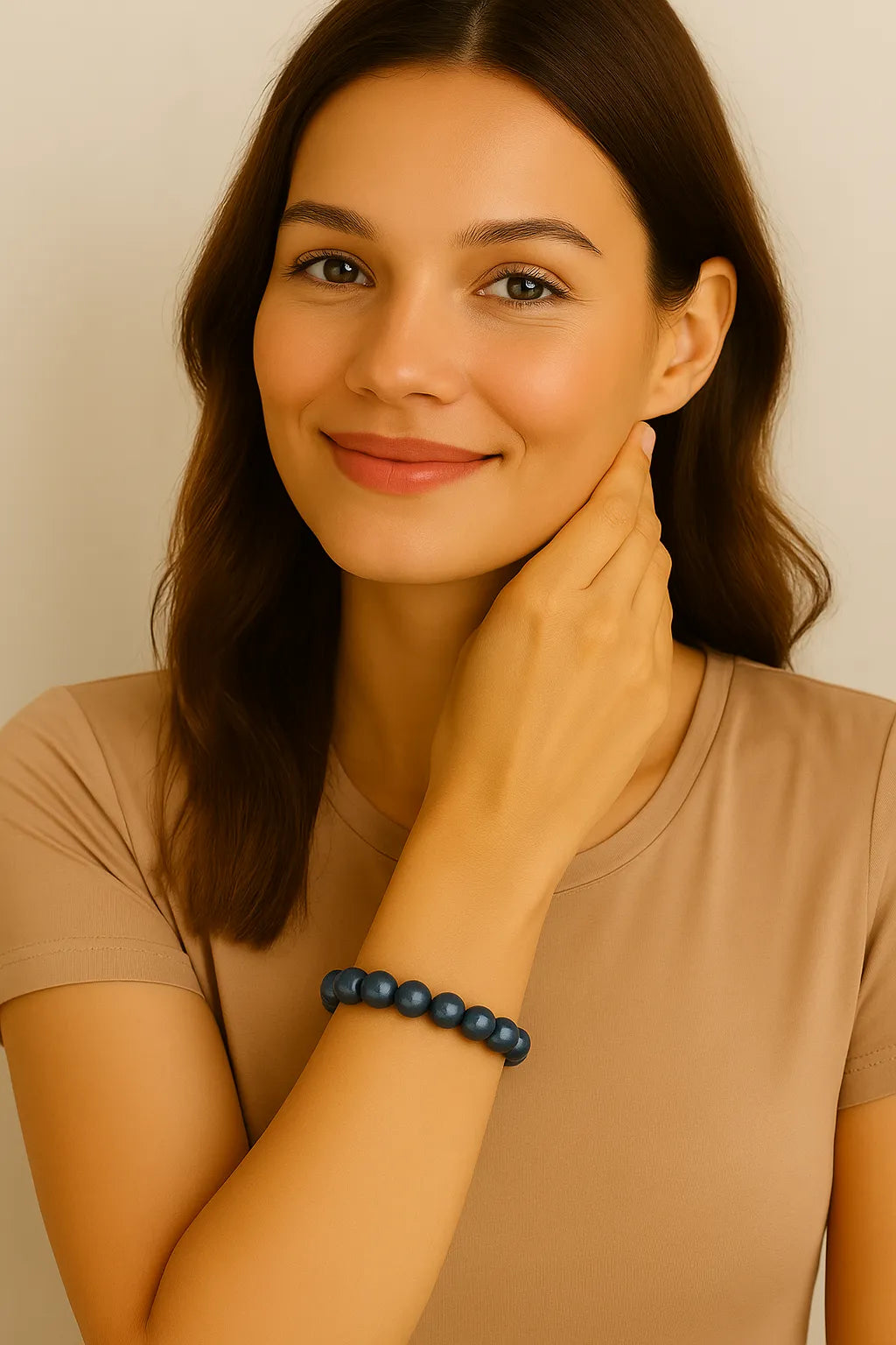 Eine junge Frau mit mittellangen braunen Haaren trägt ein elastisches Armband aus dunkelblauen, glänzenden Perlen am Handgelenk