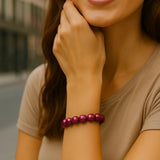 Junge Frau in urbaner Umgebung trägt ein glänzendes pink-violettes 3D Wonderperlen Armband am rechten Handgelenk, Fokus liegt auf dem Schmuckstück.