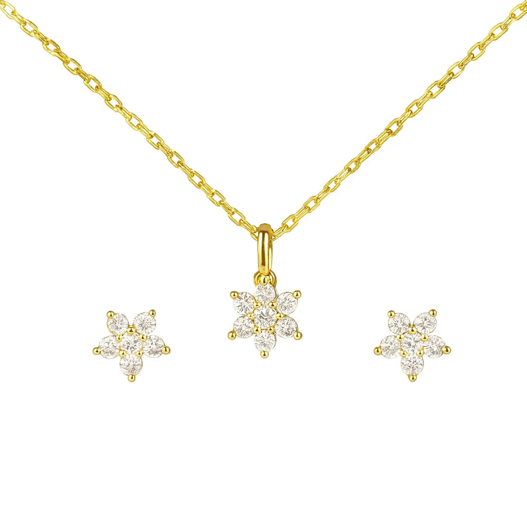Goldenes Schmuckset bestehend aus einer feinen Halskette mit blütenförmigem Anhänger und passenden Ohrsteckern, besetzt mit funkelnden Zirkonia-Steinen, vor weißem Hintergrund.